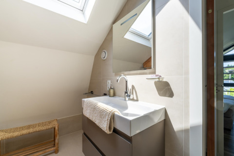 Baño moderno con tragaluz, lavabo blanco y espejo en la casa Holiday Home Waterland para seis personas en Holanda.