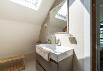 Modern bathroom with skylight, white sink and mirror at Holiday Home Waterland for six persons in the Netherlands.