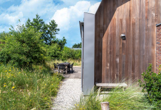 Außenbereich mit Sitzgelegenheit am Ferienhaus Waterland für sechs Personen, umgeben von Natur.