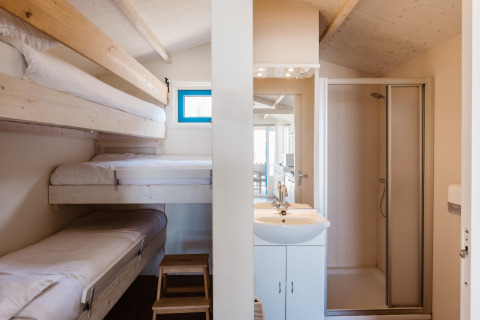 Interior view of a Beach Houses Wijk aan Zee 5 room with bunk beds and private bathroom facilities.