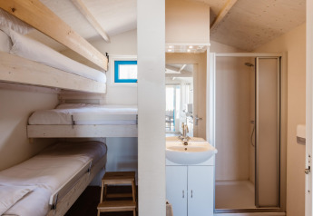 Interieur van een Beach Houses Wijk aan Zee 5-kamer met stapelbedden en een eigen badkamer.