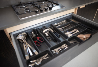 Cajón con cubiertos y utensilios de cocina organizados en Sea Lodges Zandvoort 3, Países Bajos.