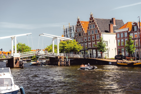 Foto de un canal holandés, puente tradicional y edificios históricos en Zandvoort, Países Bajos, en un día soleado.
