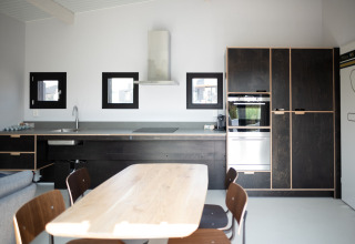 Cocina moderna y comedor en la casa de playa Sea Lodges Zandvoort 1, con un diseño luminoso y minimalista.
