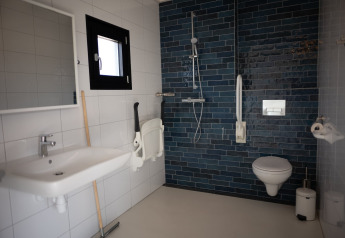 Barrierefreies Badezimmer mit Dusche, Wandtoilette und Haltegriffen in Sea Lodges Zandvoort 1, Niederlande.