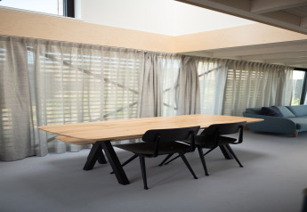 Helles, modernes Esszimmer mit Holztisch und schwarzen StĂĽhlen im Sea Lodges Zandvoort 4 Strandhaus, Niederlande.