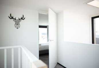 Helles, modernes Interieur des Strandhauses Sea Lodges Zandvoort 4 in den Niederlanden mit Geweihkunst.