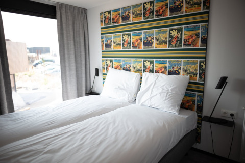 Dormitorio con dos camas individuales en Sea Lodges Zandvoort 4, decoración moderna y papel tapiz colorido.
