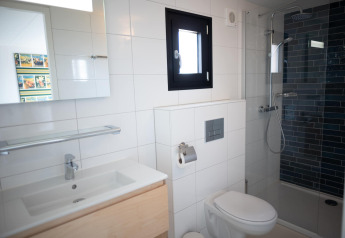 Modernes Bad in den Sea Lodges Zandvoort 4, Niederlande, mit Dusche, Toilette und Waschbecken.