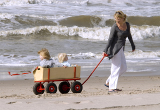 Una mujer tira de dos niños en un carro en la playa cerca de Sea Lodges Zandvoort en los Países Bajos.