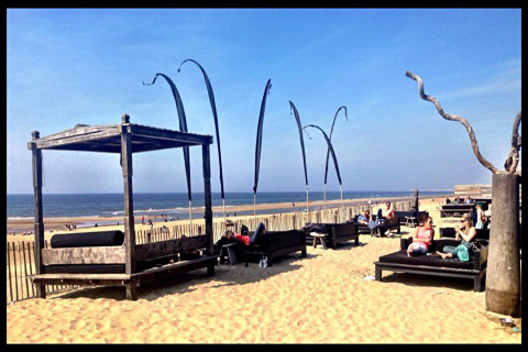Strandbeeld bij Sea Lodges Zandvoort in Nederland met ligbanken, mensen en zicht op de zee.