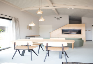 Salón luminoso y moderno con mesa de comedor y sofá verde en Sea Lodges Zandvoort 3, Países Bajos.