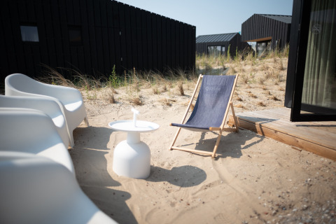 Sillas modernas y tumbona en las dunas de arena frente a Sea Lodges Zandvoort 3, en los Países Bajos.