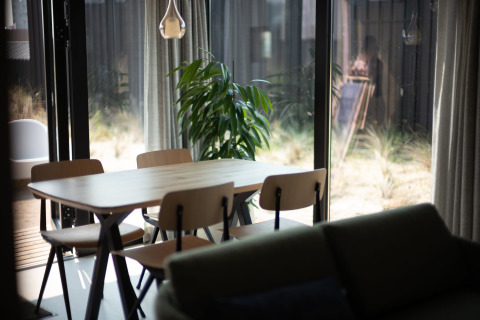 Luminoso comedor de la casa de playa Sea Lodges Zandvoort 3 en los Países Bajos con mesa y sillas.