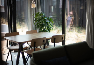 Luminoso comedor de la casa de playa Sea Lodges Zandvoort 3 en los Países Bajos con mesa y sillas.