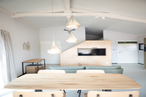 Interior luminoso y moderno de Sea Lodges Zandvoort 3 en Países Bajos, con mesa, sofá y televisor.