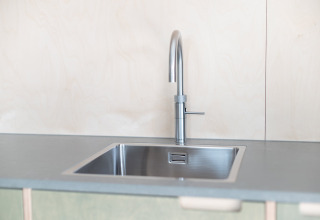 Fregadero y grifo de acero inoxidable moderno en la cocina de Sea Lodges «Zandvoort 3», Países Bajos.