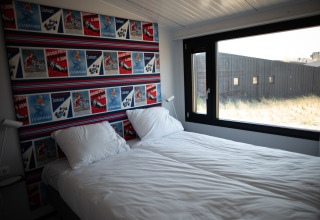 Dormitorio en la casa de playa Sea Lodges Zandvoort 9 en los Países Bajos con cama doble y ventana grande.