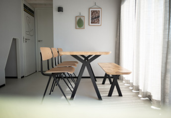Moderne Esszimmer im Sea Lodges Zandvoort 9, Niederlande, mit Holzbank, StĂĽhlen und viel Sonnenlicht.