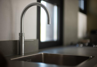 Grifo y fregadero modernos en la cocina de Sea Lodges «Zandvoort 9» en la playa de los Países Bajos.