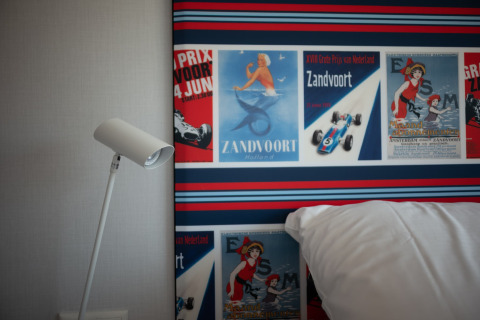 Interior de Sea Lodges Zandvoort 9 en la playa de los Países Bajos con pósters retro y lámpara moderna.
