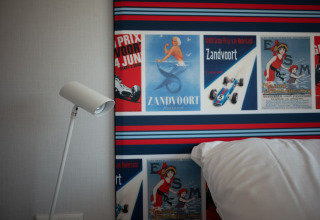 Interior de Sea Lodges Zandvoort 9 en la playa de los Países Bajos con pósters retro y lámpara moderna.