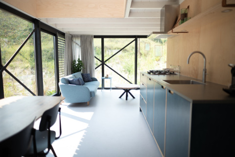 Cocina y sala modernas y luminosas en Sea Lodges Zandvoort 9, Países Bajos, con vista a las dunas.