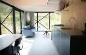 Helles, modernes KĂĽchen-Wohnzimmer in den Sea Lodges Zandvoort 9 mit groĂźen Fenstern und DĂĽnenblick.