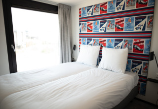 Dormitorio en Sea Lodges Zandvoort 9, Países Bajos, con dos camas individuales y cabecera decorada.