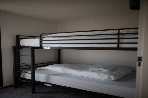 Literas con estructura negra y sábanas blancas en una habitación de Sea Lodges Zandvoort 9, Países Bajos.
