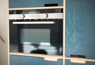 Horno empotrado moderno en una casa de playa, Sea Lodges «Zandvoort 9», con armarios azules en Holanda.
