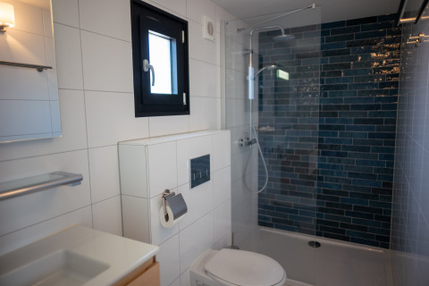 Baño moderno en la casa de playa Sea Lodges Zandvoort 9, Países Bajos, con ducha y azulejos blancos.