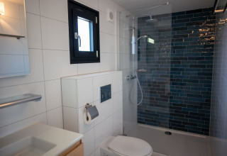 Baño moderno en la casa de playa Sea Lodges Zandvoort 9, Países Bajos, con ducha y azulejos blancos.