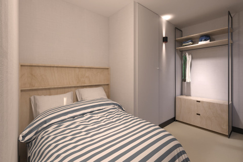 A modern bedroom with a single bed, striped bedding, and open wardrobe at Sea Lodges Zandvoort 11, Netherlands.
