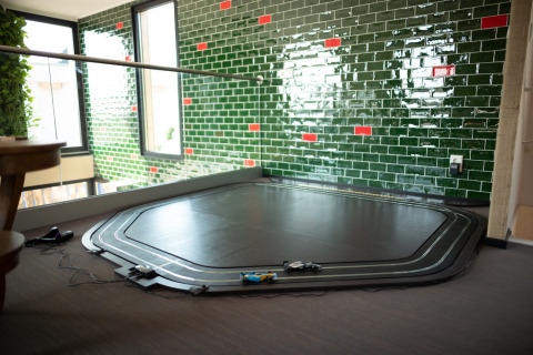 Toy race track on the floor in a modern room with green tile walls at Sea Lodges Zandvoort 11, Netherlands.