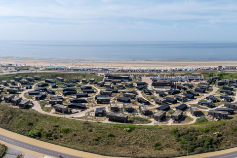Vista aérea de Sea Lodges 'Zandvoort 9' en los Países Bajos, con casas junto a la playa y el mar.