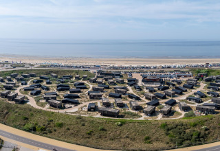 Vista aérea de Sea Lodges 'Zandvoort 9' en los Países Bajos, con casas junto a la playa y el mar.