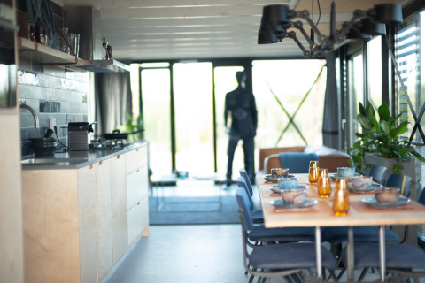 Moderne keuken en eetruimte in Sea Lodges Zandvoort 6 strandhuis, tafel gedekt en glazen wanden.
