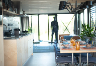Moderne keuken en eetruimte in Sea Lodges Zandvoort 6 strandhuis, tafel gedekt en glazen wanden.