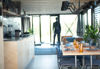 Moderne keuken en eetruimte in Sea Lodges Zandvoort 6 strandhuis, tafel gedekt en glazen wanden.