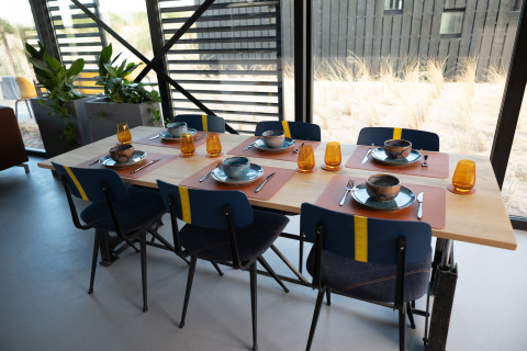 Eettafel gedekt voor zes in het moderne Sea Lodges Zandvoort 6 strandhuis met duinzicht, Nederland.