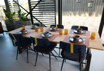 Eettafel gedekt voor zes in het moderne Sea Lodges Zandvoort 6 strandhuis met duinzicht, Nederland.