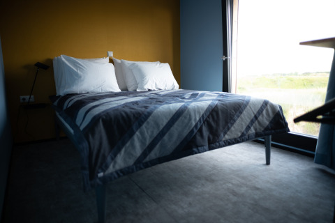 Lichte moderne slaapkamer in Sea Lodges Zandvoort 6 in Nederland, met comfortabel bed en ruim raam.