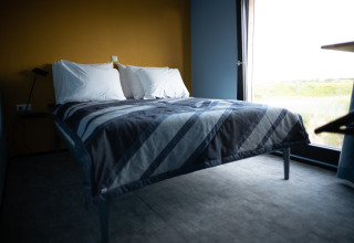Lichte moderne slaapkamer in Sea Lodges Zandvoort 6 in Nederland, met comfortabel bed en ruim raam.