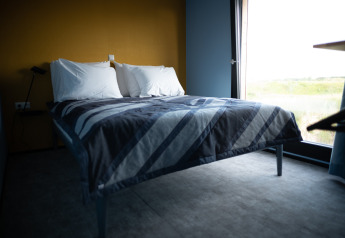 Lichte moderne slaapkamer in Sea Lodges Zandvoort 6 in Nederland, met comfortabel bed en ruim raam.