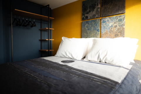 Moderne slaapkamer in Sea Lodges Zandvoort 6 met wit linnengoed en kunst aan de muur in Nederland.