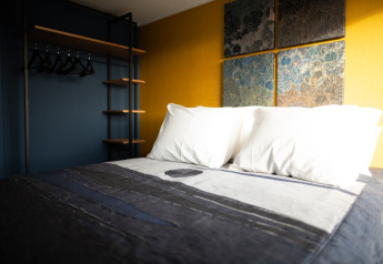 Moderne slaapkamer in Sea Lodges Zandvoort 6 met wit linnengoed en kunst aan de muur in Nederland.