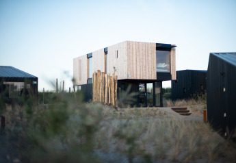 Modern strandhuis Sea Lodges ‘Zandvoort 6’ in Nederland, omringd door duinen en grassen.