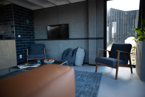 Moderne zithoek in Sea Lodges Zandvoort 6, Nederland, met blauwe zetels en grote ramen.