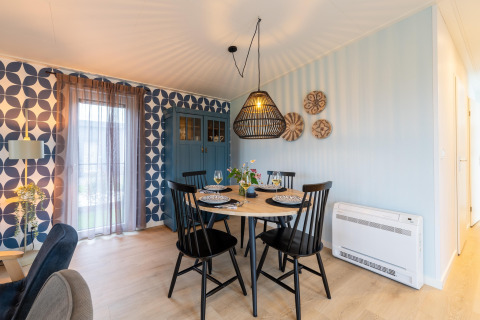 Moderner Essbereich mit schwarzem Tisch, Stühlen, gemusterten Tapeten und blauem Schrank in 'By the Baker', Niederlande.